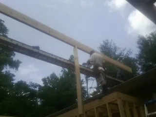 Carpenter setting a ridge beam over a new addition frame — Ice Dam Removal by Roofing Brothers in Nanticoke